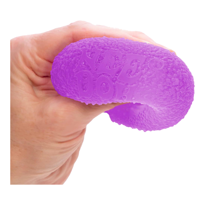 HypeSelection NeeDoh Gumdrop Purple being squeezed in a hand to show its firm sensory squish.