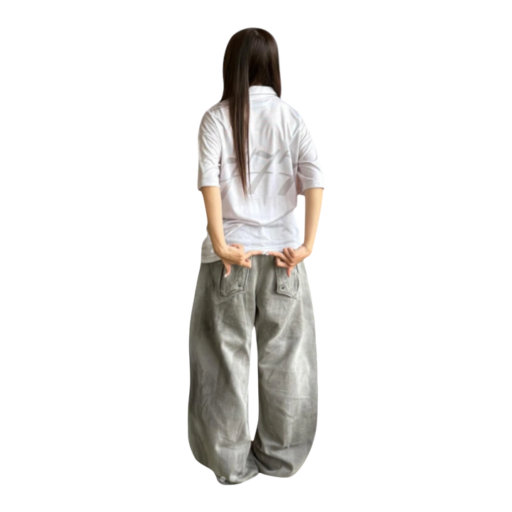HADES Legends Spirit Jersey in white polyester mesh blend. Oversized fit with athletic graphics and striped detailing. Model wears it with baggy grey pants.