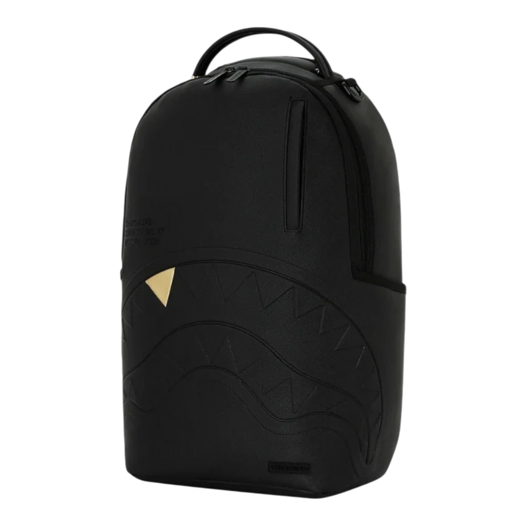 HypeSelection Sprayground blacked out backpack featuring embossed shark mouth design and a gold tooth detail.