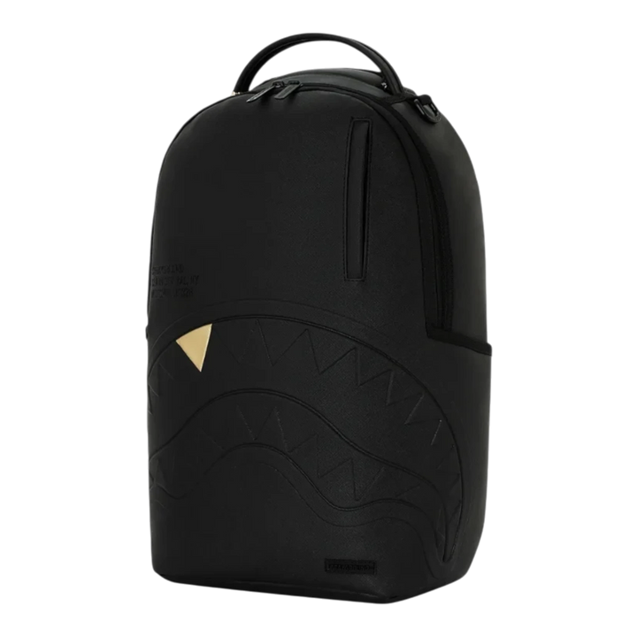 HypeSelection Sprayground blacked out backpack featuring embossed shark mouth design and a gold tooth detail.