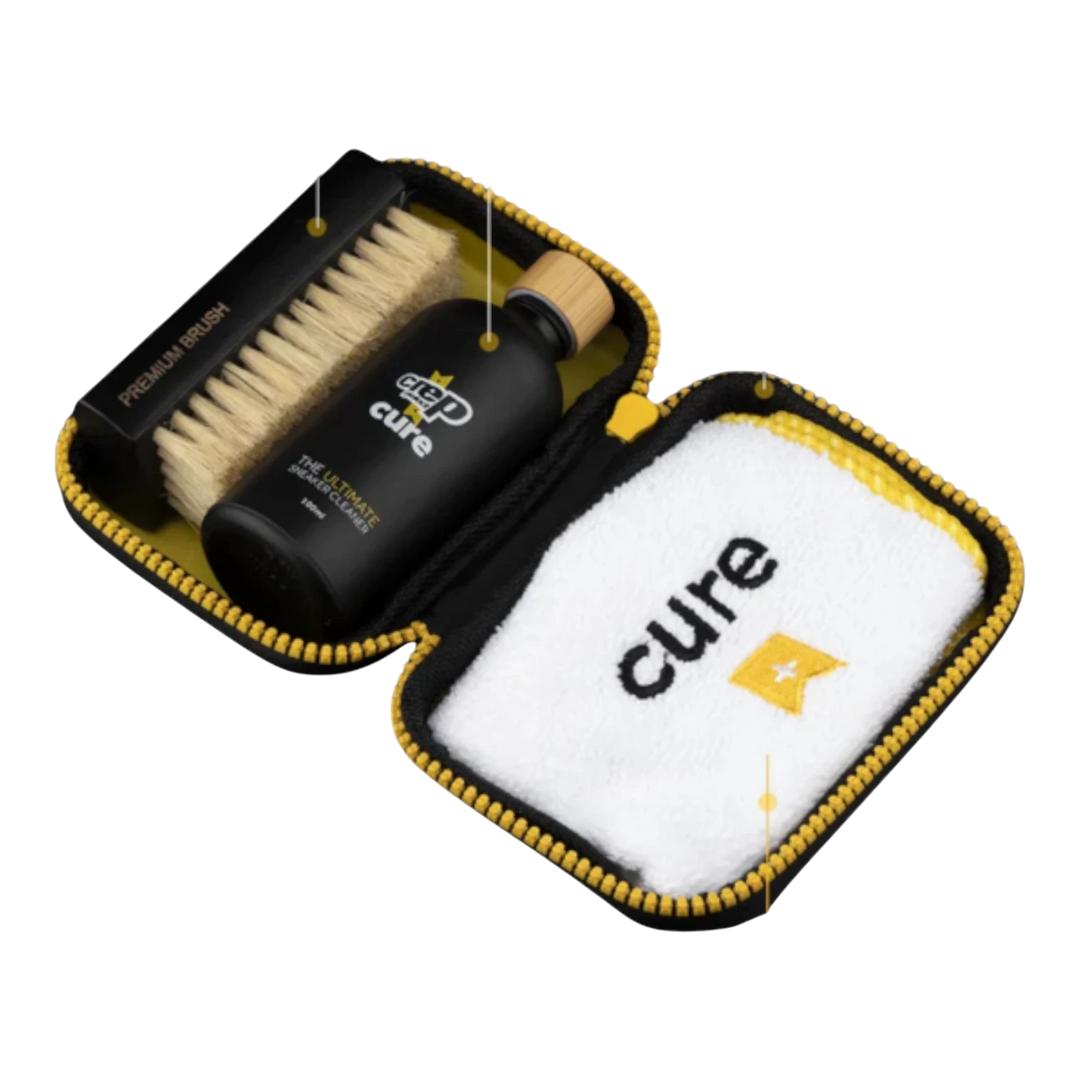 HypeSelection Crep Protect Cure Ultimate Cleaning Kit with cleaning solution, brush, and microfiber cloth in a black and yellow case.