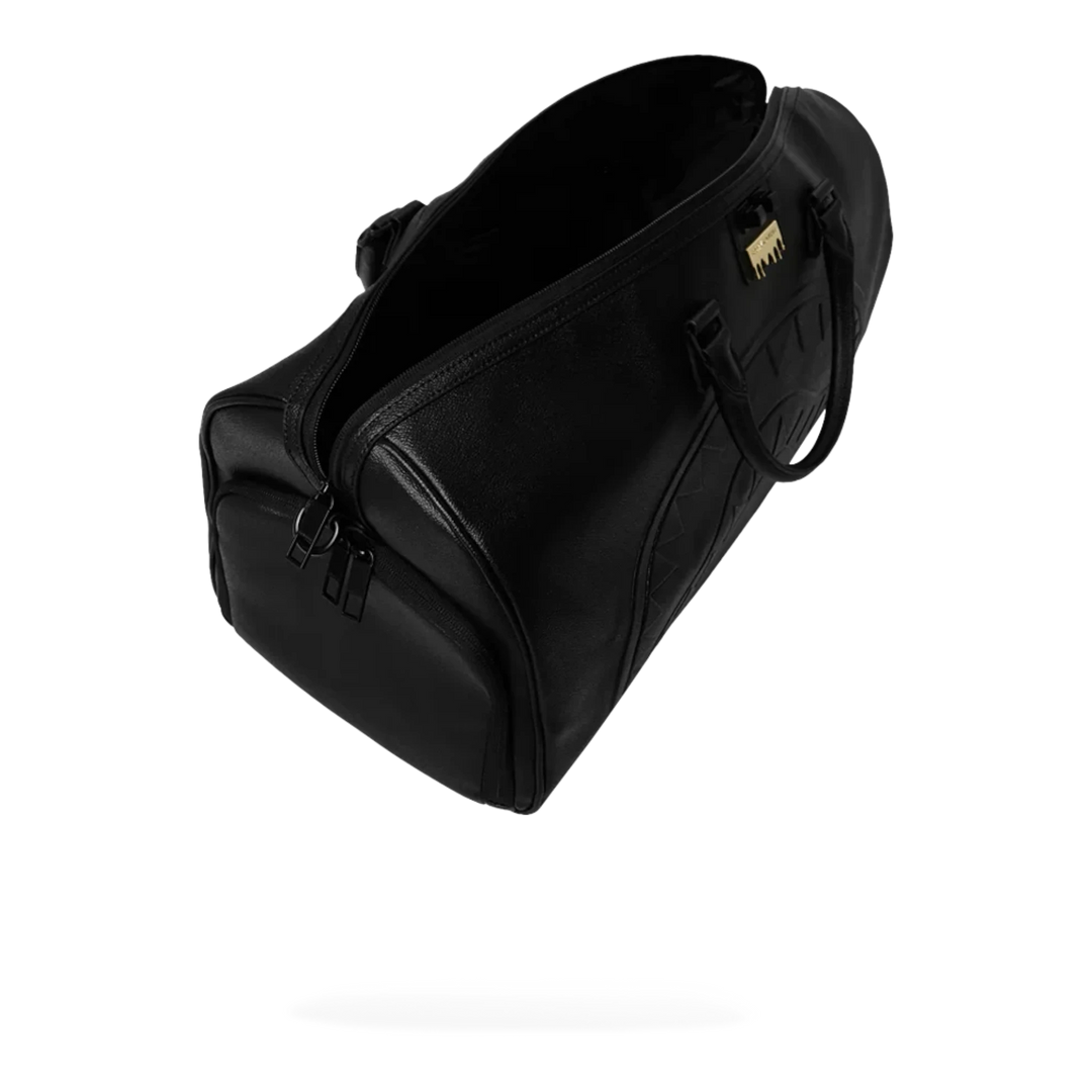 HypeSelection black eco-leather duffle bag with all-over gold brick pattern and gold hardware. Features zip pockets and shoulder strap.