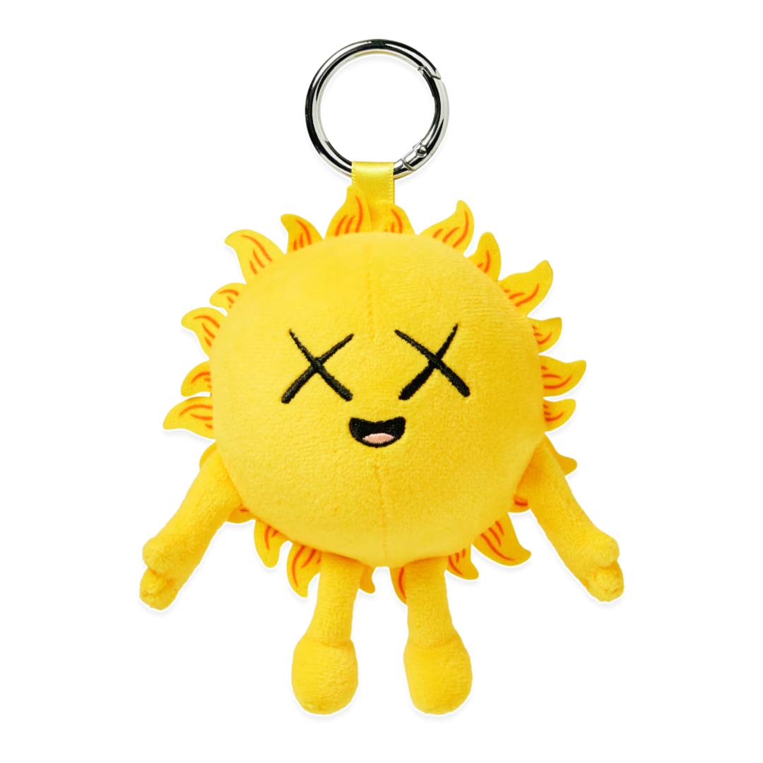 HypeSelection KAWS Universe yellow sun plush charm with signature X eyes and metal keyring for bags and accessories.