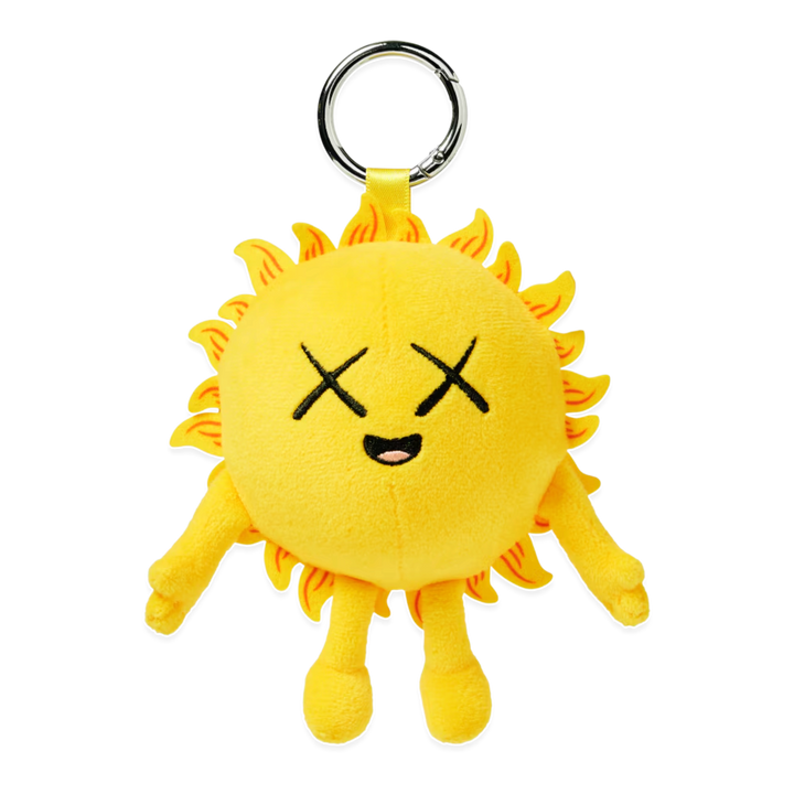 HypeSelection KAWS Universe yellow sun plush charm with signature X eyes and metal keyring for bags and accessories.