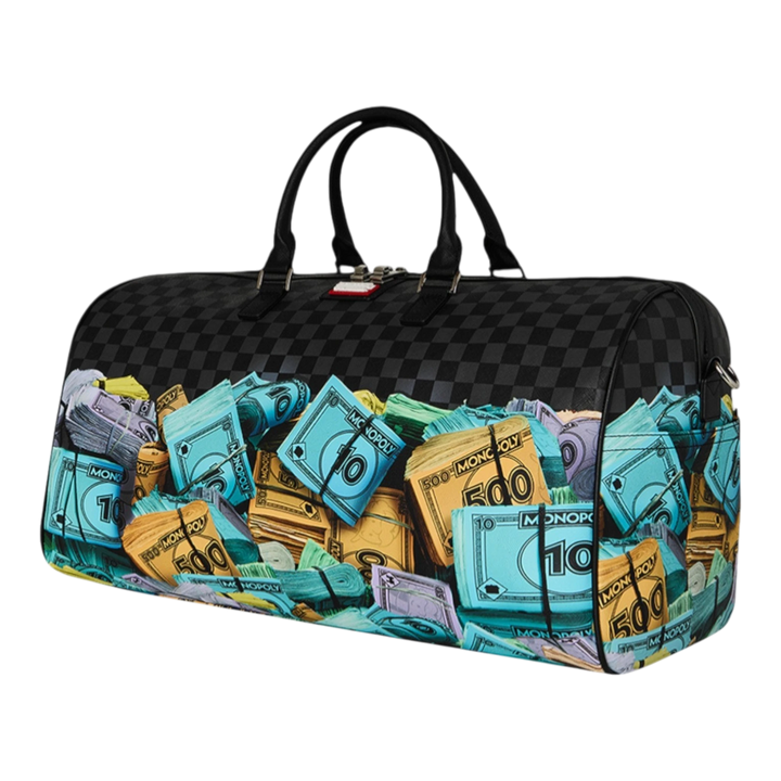HypeSelection duffle bag with all-over Monopoly money stacks graphic print, black checkerboard pattern, and dual handles.