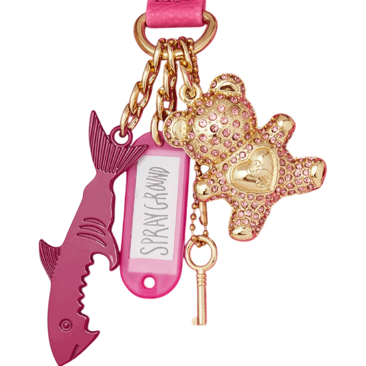 HypeSelection: Pink shark and teddy bear bag charms with gold accents and key detail.