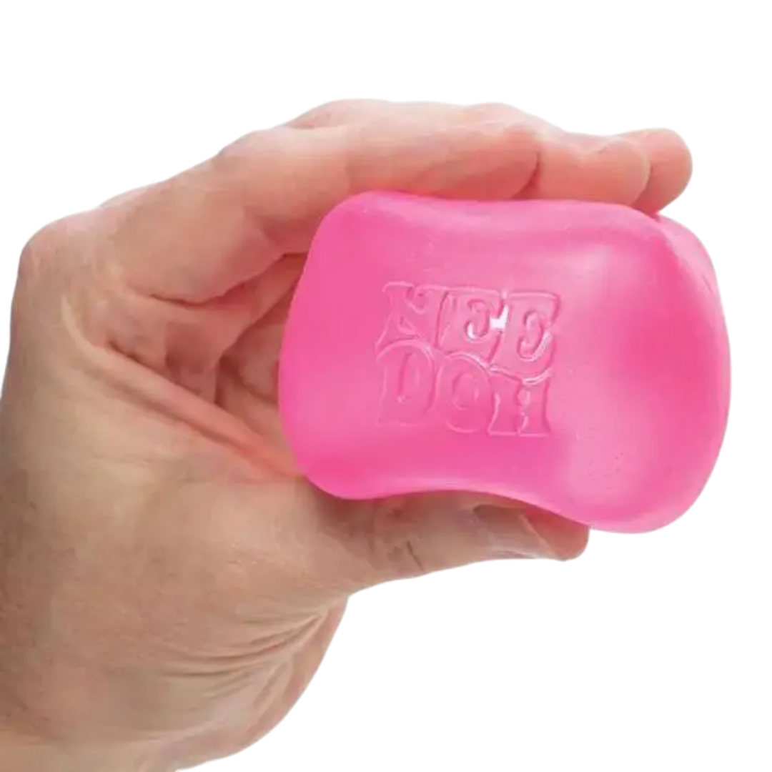 HypeSelection pink squishy NeeDoh Nice Cube fidget toy held in hand, made of TPE with gel filling.