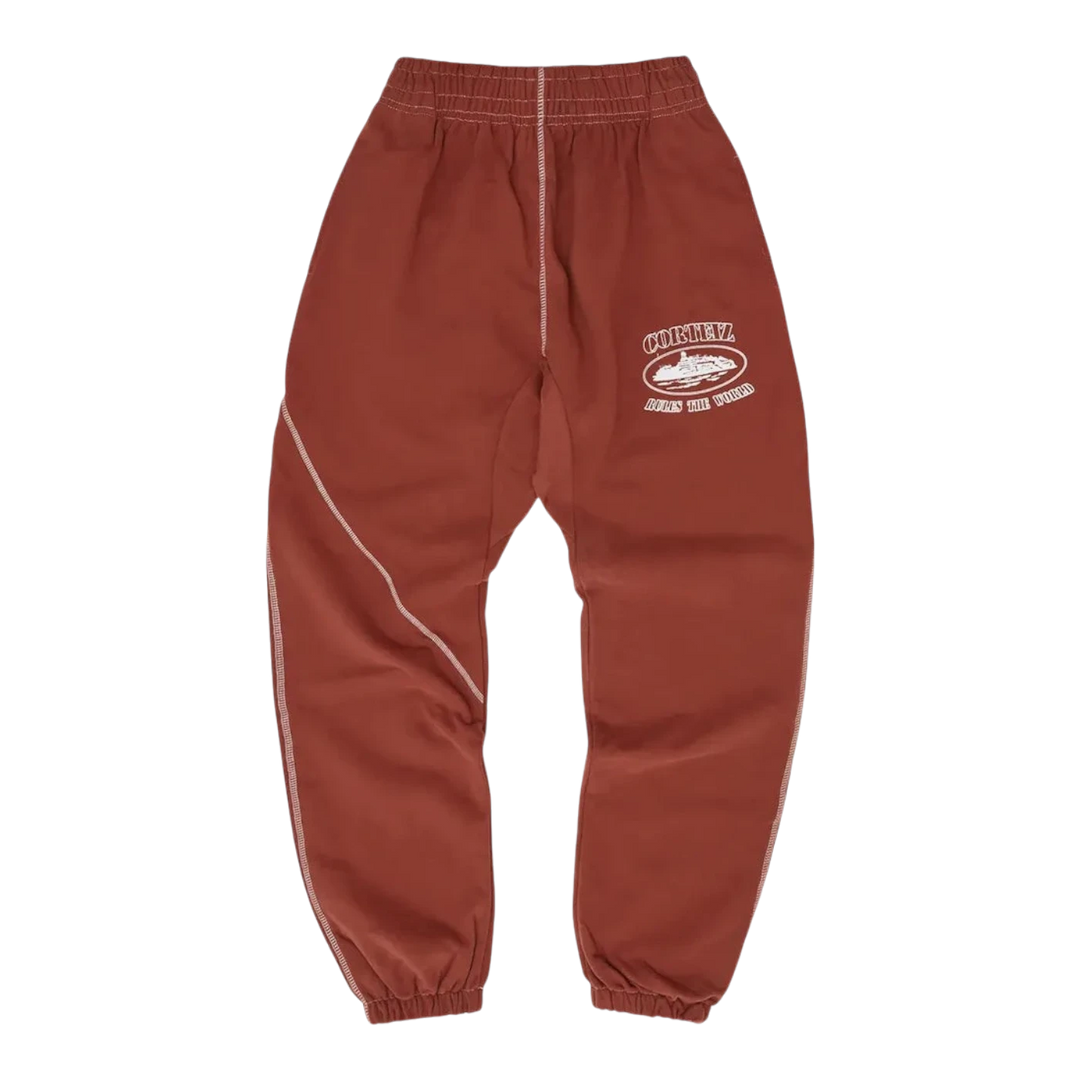 HypeSelection rust-colored cotton blend sweatpants with a relaxed fit and elastic waistband, featuring the Corteiz logo on the left thigh.