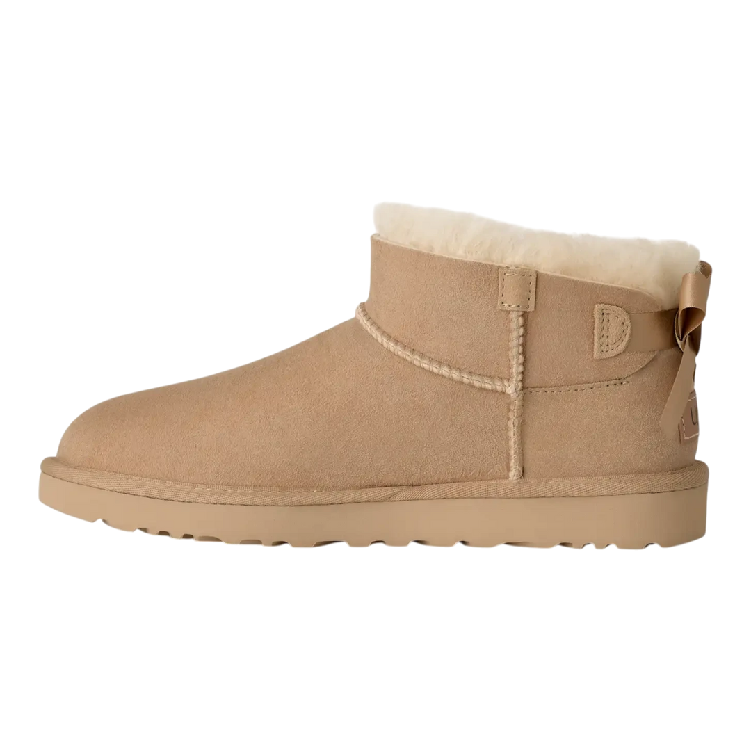 HypeSelection UGG Ultra Mini Bailey Bow boot in sand suede with plush wool lining and back satin bow detail