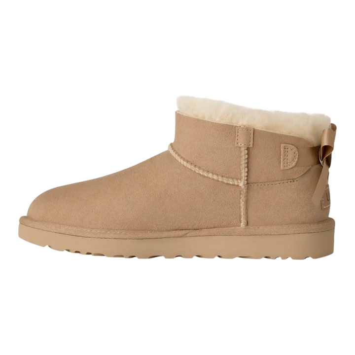 HypeSelection UGG Ultra Mini Bailey Bow boot in sand suede with plush wool lining and back satin bow detail