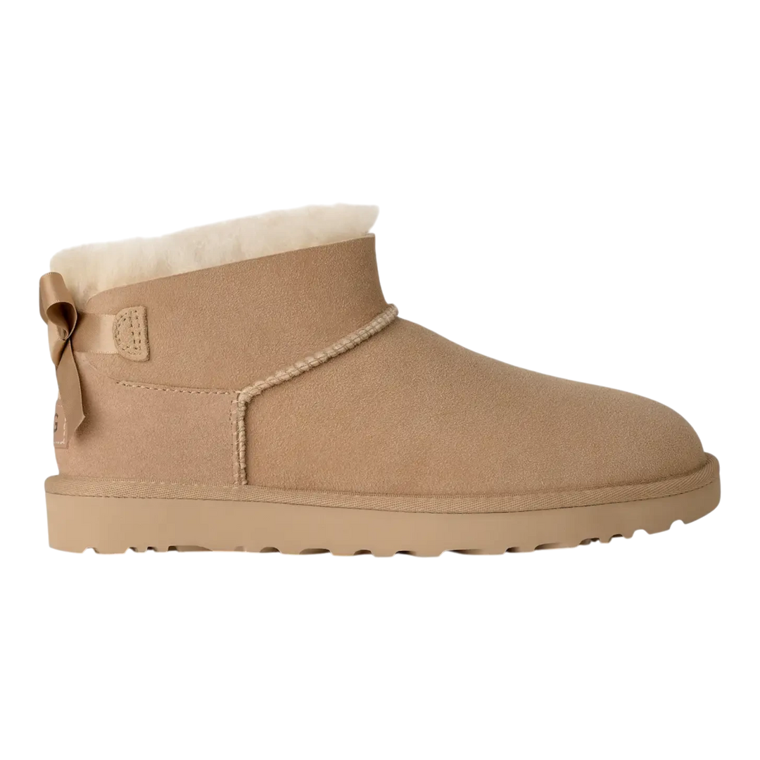 HypeSelection UGG Ultra Mini Bailey Bow boot in sand suede with a plush wool lining and back satin bow detail