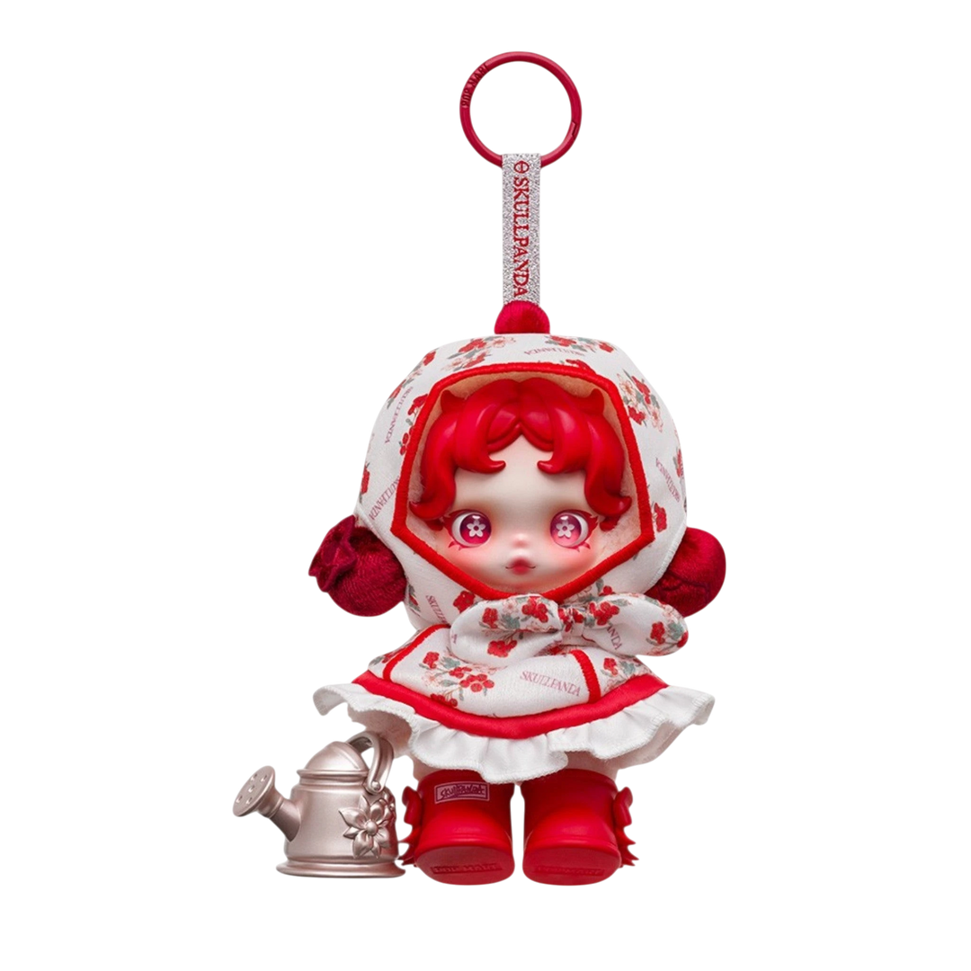 HypeSelection SKULLPANDA Amid Flowers plush doll pendant with red hair, floral print dress, and red boots, holding a watering can.