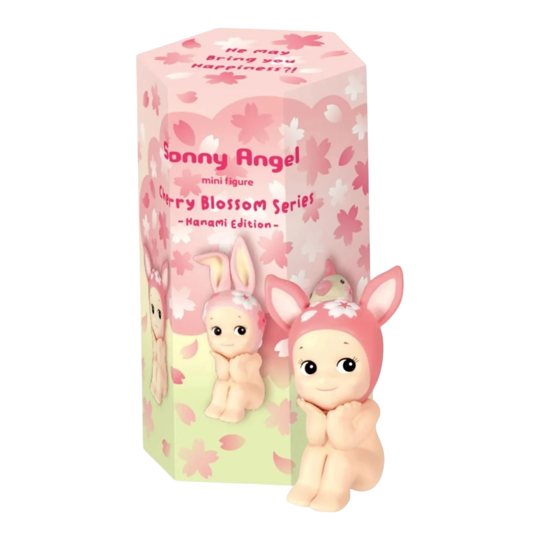 Sonny Angel Cherry Blossom Hanami Edition mini figure in pink bunny hat, sitting with hands on cheeks. Box features cherry blossom design.