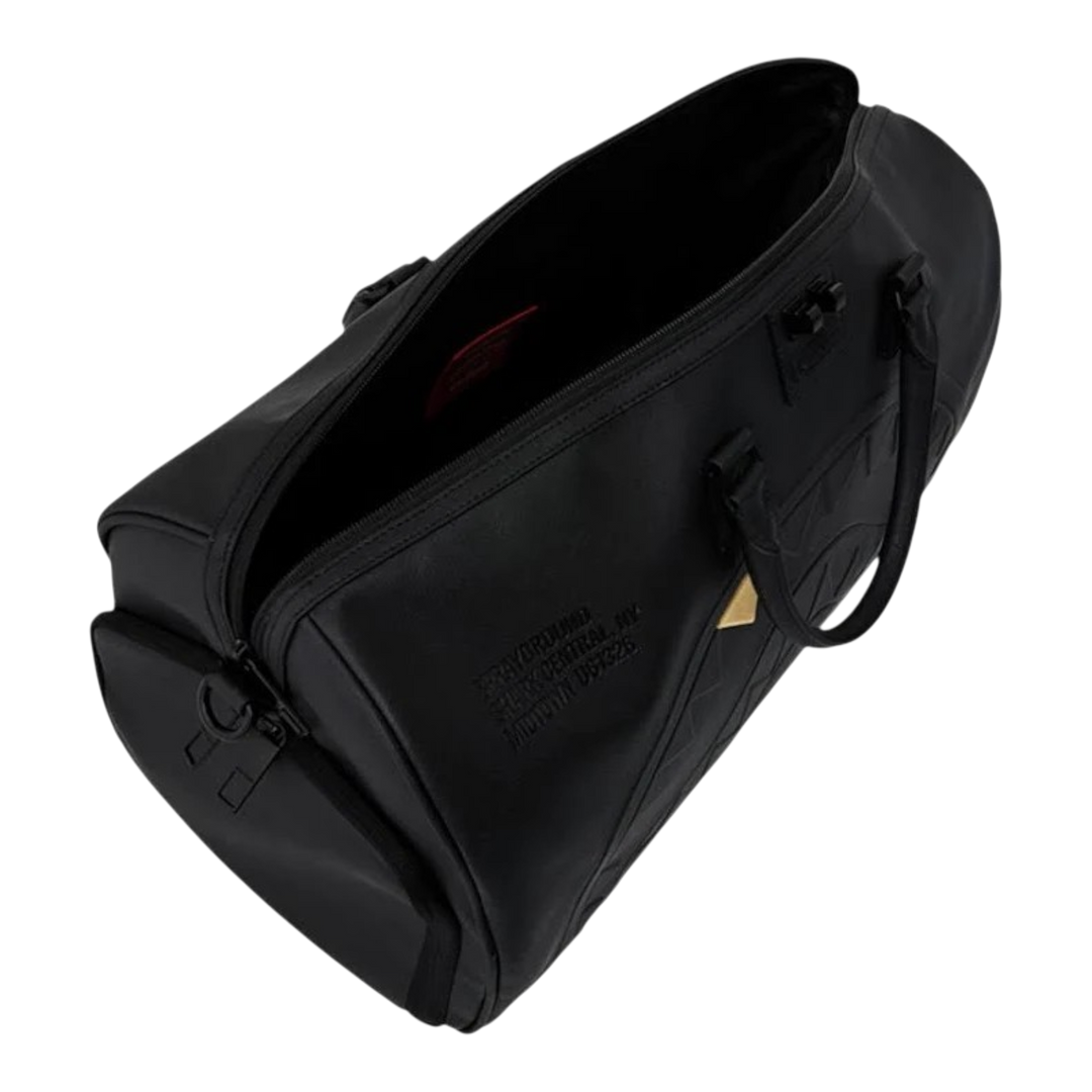 HypeSelection Sprayground black duffle bag with embossed sharkmouth design and gold tooth detail, top view.