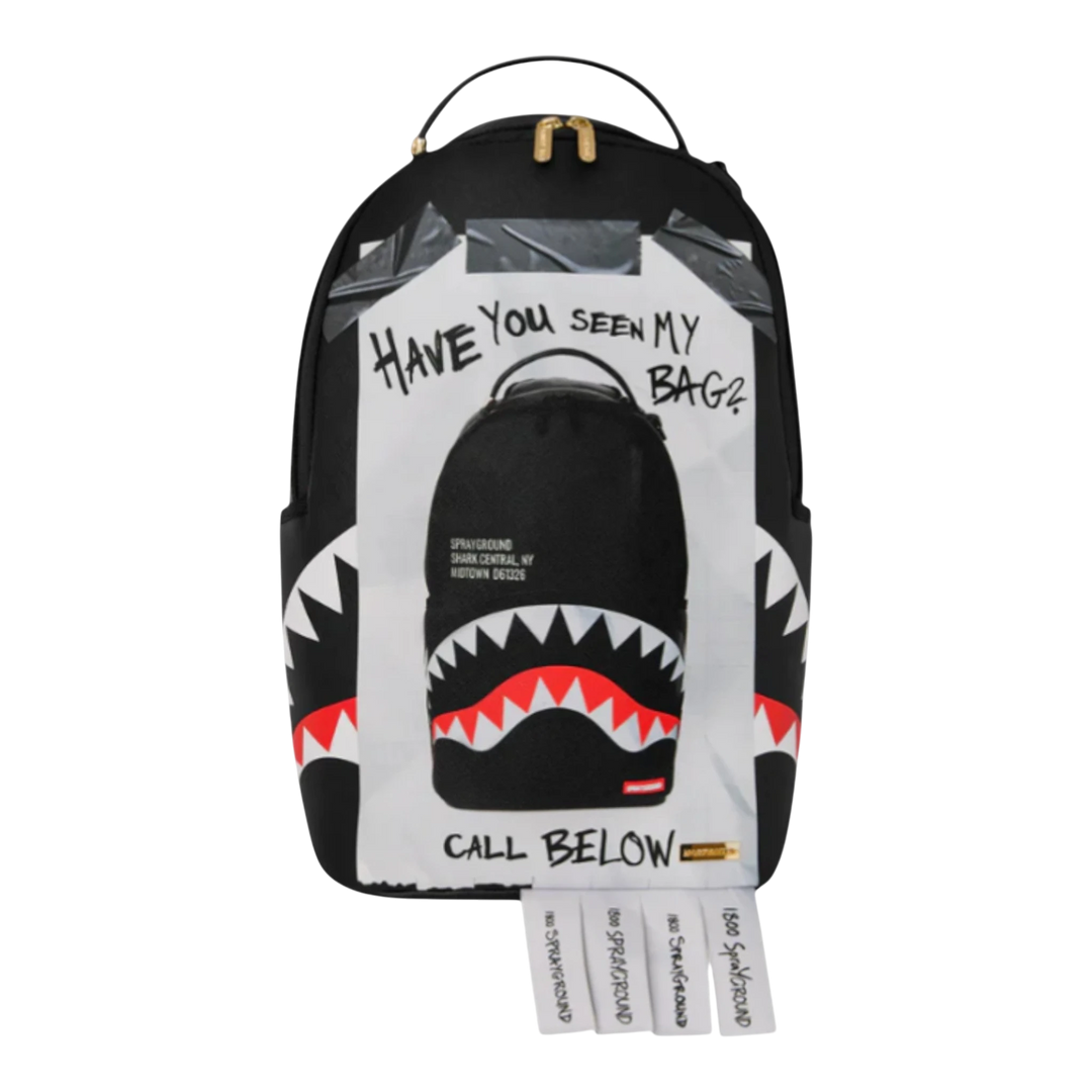 HypeSelection Sprayground Missing Bag Flyer backpack with shark teeth graphic and tear-off phone number tabs. Black faux leather.