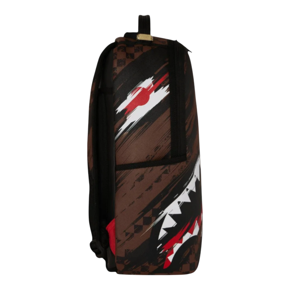 HypeSelection Sprayground Smeared Grunge backpack with brown, black, red, and white graphic print. Features a shark mouth design and checkered pattern.