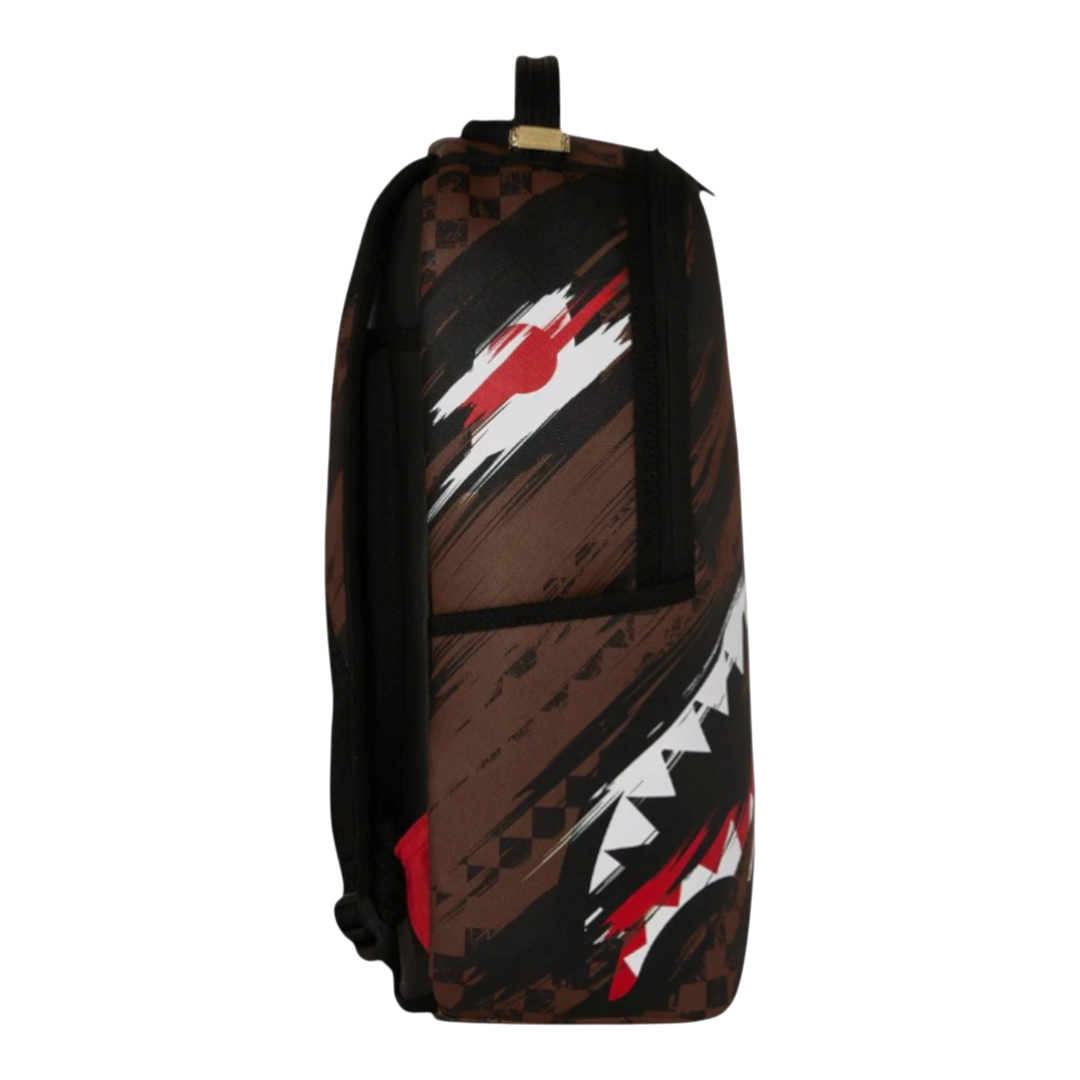 HypeSelection Sprayground Smeared Grunge backpack with brown, black, red, and white graphic print. Features a shark mouth design and checkered pattern.