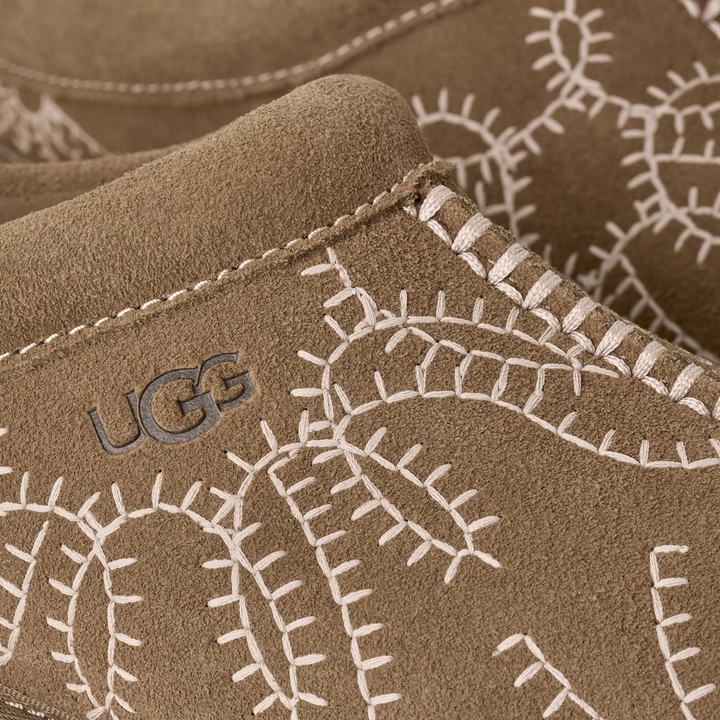 HypeSelection UGG Tazz Botanic slipper in light bronze suede with detailed white botanical embroidery and UGG logo